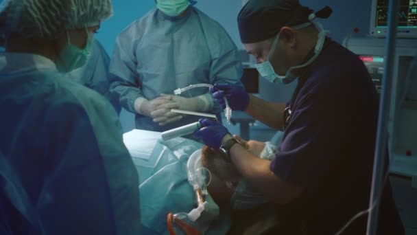 麻醉师在外科医生和护士的簇拥着下完成病人生命功能的特写 — 图库视频影像