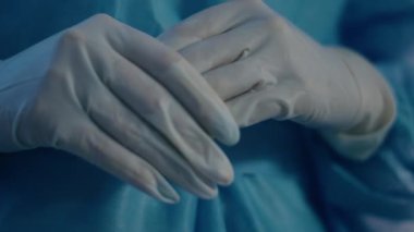 Hastanede kameraya yakın çekim yaparken, bir doktorun tüm ekipmanlarını ve koruyucu eldivenlerini kaydediyor..