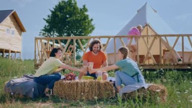 Mutlu ve heyecanlı bir grup arkadaş kamp alanında birlikte iyi vakit geçiriyorlar. Bir adam arkadaş grubuna gelip merhaba diyor ve oturuyor. 4k