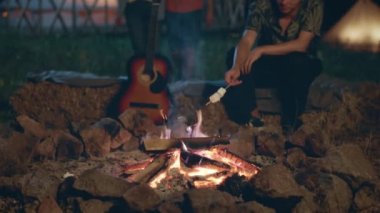 Kamp alanında çok karizmatik arkadaşlardan oluşan bir grup yangın kazığının yanına oturur ve iyi vakit geçirirken gitarı biraz marşmelov pişirir. ARRI 'de çekilen