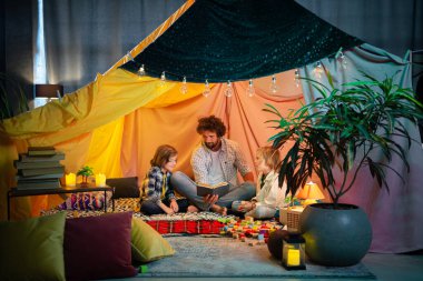 Yakışıklı bir baba ve iki genç oğlu çok modern ve rahat battaniyeleriyle hikaye kitabı okuyorlar çünkü atmosfer çok rahatlatıcı ve sevimli. Aile