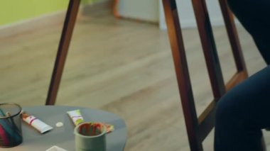 Sanat atölyesinde çalışan bir ressamın büyük bir tuvale bazı soyut sanat eserleri çizdiği yakın plan. ARRI Alexa Mini 'de çekilen