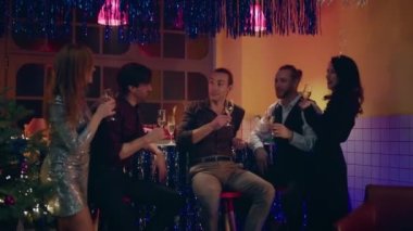 Gece kulübünde arkadaşlarıyla birlikte yakışıklı erkekler Noel 'i ya da yeni yıl partisini kutlayan güzel bayanlarla birlikte şampanya içip gecenin tadını çıkarıyorlar. 4k
