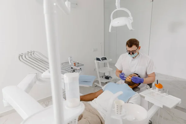 Modern Tandvårdsklinik Tandläkare Med Hjälp Dentala Instrument För Tandvård Patienten Stockbild