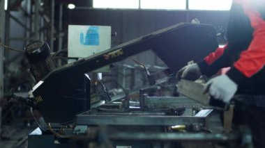 Endüstriyel üretim bölgesi karizmatik işçi işçi güvenlik miğferi ve ekipmanı ile kesilmeye başlamadan önce metali ölçer. 4k