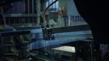 Endüstriyel fabrikada çalışan bir makinenin detaylarını kaydederken makine bazı sert materyalleri kesiyor..