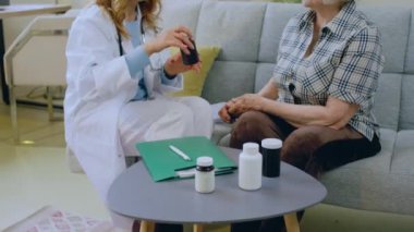 Pratisyen hekim, evdeki hastasını ziyarete geldi. İlaç haplarını tartıştılar. Doktor birkaç hap aldı ve yaşlı kadına verdi. 4k