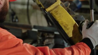 Üretim fabrikası ağır makinelerle metali kesme sürecini yakalıyor..