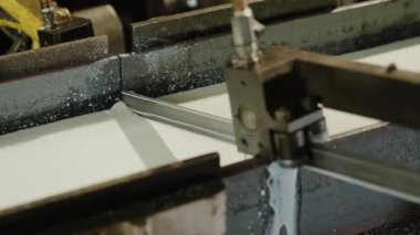 Kameranın önünde, ağır endüstriyel makineler kullanarak metali kesmenin detaylarını çekerken..