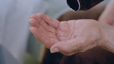 Kameraya yakın çekim detayları eski el sıkışması şişeden biraz tıbbi hap çıkar ve almaya hazır ol. 4k