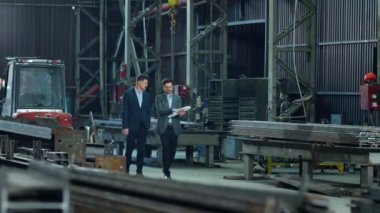 Mühendis deposu ve yatırımcı imalat fabrikası analizinde yürüyor ve üretim hattının geliştirilmesi ve çalışma planı hakkında tartışıyorlar..