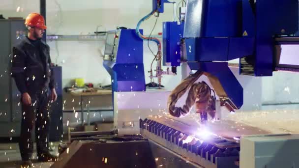 工厂工人穿着安全设备站在重型工业机械旁边自动焊接金属 — 图库视频影像