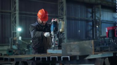 Metalle çalışan profesyonel demircinin önünde ağır bir makineyle metali kesmiş..