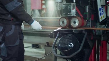 Fabrika işçisi demirci bir metal parçası kullanıyor ve baskı altında güvenlik ekipmanı ve eldiven takıyor..