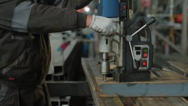 拍摄了一个铁匠在金属制造业工作的视频细节 他使用特殊的专业重型机械在金属上打孔 — 图库视频影像