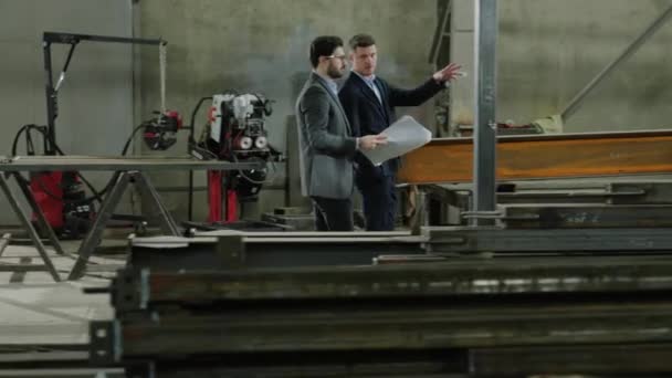 工厂前的摄像头走着两个高加索人的工程师和商人一起讨论这个项目 — 图库视频影像