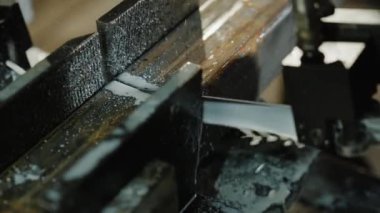 Ağır bir endüstriyel makinenin sert metal parçalarını keserken yakalanan ayrıntılar.