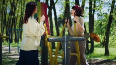 Parkta iki karizmatik bayan dışarıda spor yapıyor ve biraz temiz hava alıyor. Birlikte vakit geçiriyorlar..