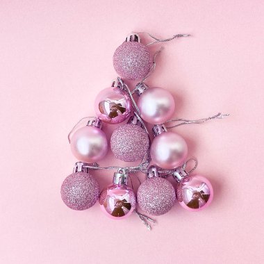 Beyaz arka planda pembe takılar olan Noel süslemeleri.