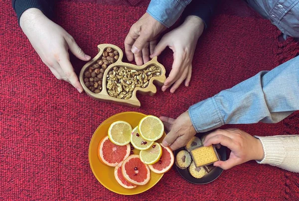 Kesilmiş insan elleri turunçgiller ve fındıklar alıyor.