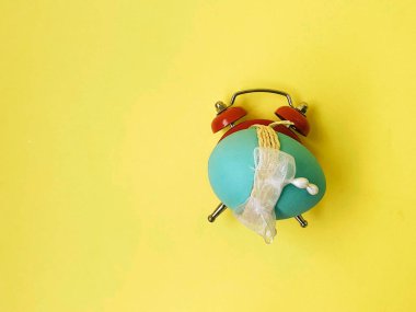 Paskalya konsepti, sarı zemin üzerinde yumurta olan çalar saat.