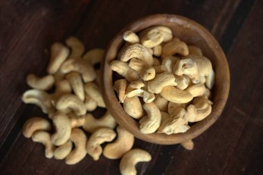 roasted cashew nuts in bowl on wood background. healthy food and nutrition.