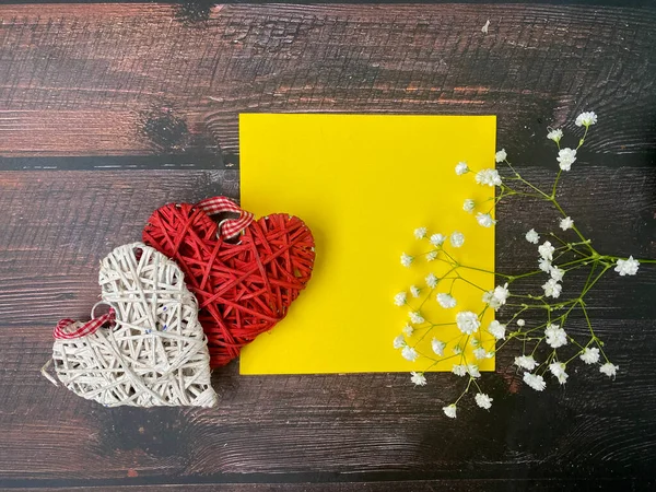 heart shaped envelope with flowers and hearts on wooden background