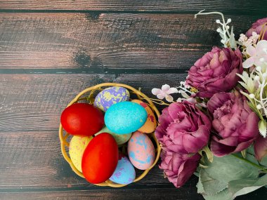 easter eggs and flowers over the wooden background