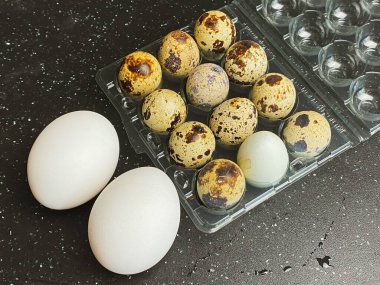 Siyah arka planda bıldırcın ve tavuk yumurtası.