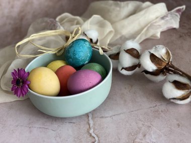 Yumurtalı, söğütlü, pembe ve mavi arka planlı paskalya kompozisyonu.