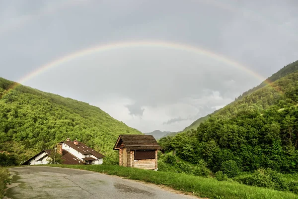 a small wooden house and rainbow   in the  mountain region
