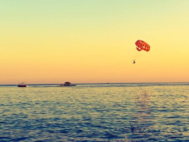 Arka planda bir deniz üzerinde bir paraglider.