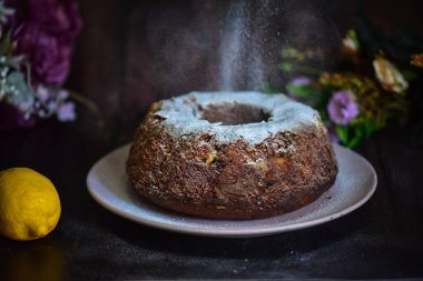 Siyah arka planda kuru üzüm ve şekerli ev yapımı pasta.