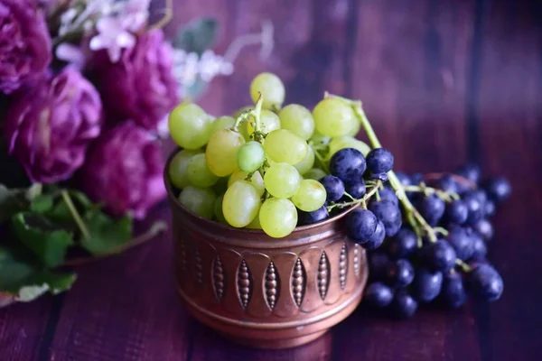 在一张木桌一只篮子里的葡萄 — 图库照片