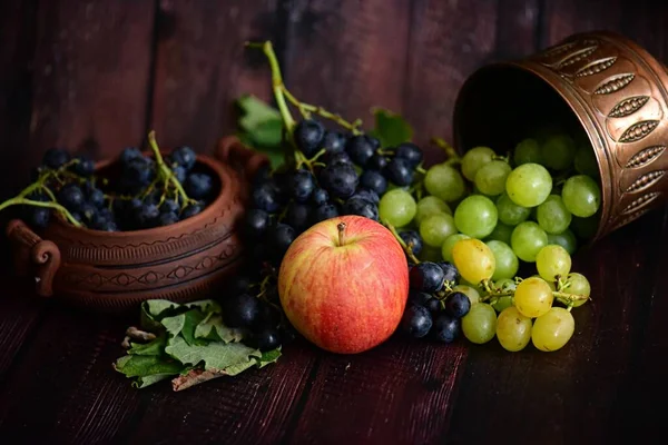 木桌上有叶子的新鲜成熟葡萄 — 图库照片