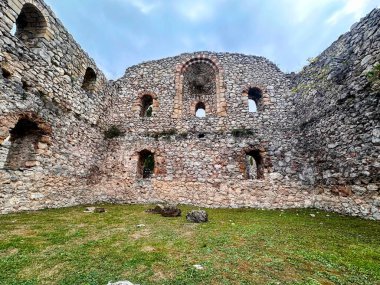 Dağlarda bulutlu bir gökyüzünün arka planındaki ortaçağ şatosunun kalıntıları. Necroo Kalesi 'nin antik kalıntıları.