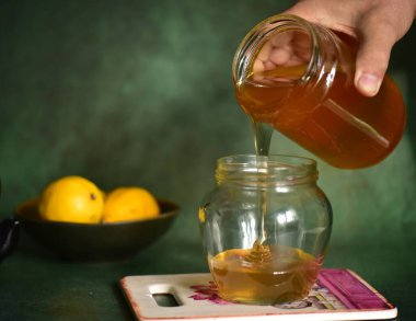 Kadın ballı, limonlu ve nane şekerli kavanozu tutuyor.