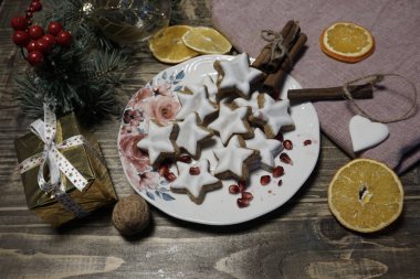 Noel kompozisyonu olarak bir pasta, bir mum, Noel süslemeleri ve ahşap bir masanın üzerindeki Noel süsü. Noel arkaplanı, yeni yıl arifesi, kış