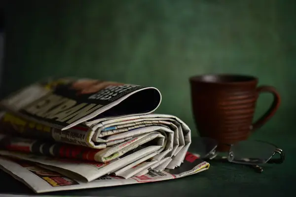 old newspaper and coffee cup on wooden table