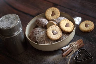 Tahta arka planda sütü olan kupa şeklinde kurabiyeler. Noel ve mutlu yıllar konsepti. en üstteki görünüm.