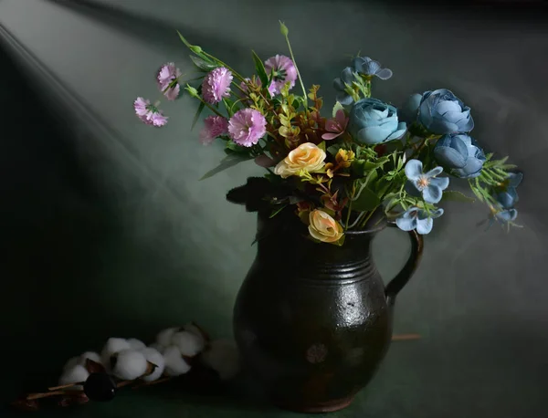 still life with flowers on dark green background