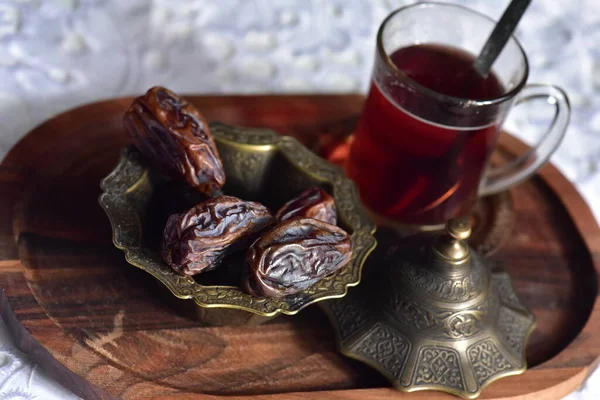 Bir fincan Türk çayı ve ahşap arka planda hurma..