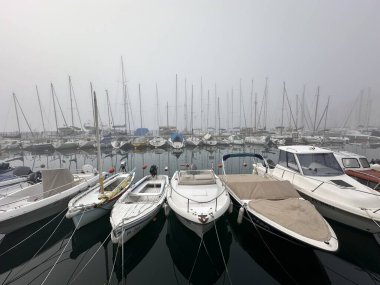 Sisli bir günde rıhtımda park etmiş teknelerin yakın çekimi.