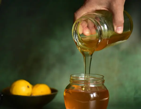 honey with lemon, lemon, mint in a wooden spoon.
