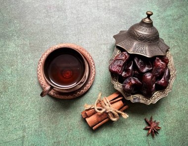 Bir fincan çay, çaydanlık ve kurutulmuş meyve bir masada.