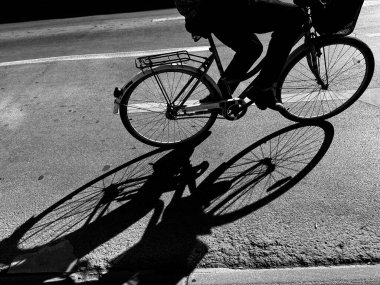 Sokakta bisikletli bir adamın silueti.