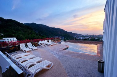 Gün batımında güzel deniz ve şehir manzaralı havuz..