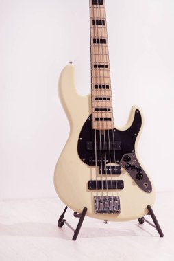 Rock Bass Guita 'nın yakınında beyaz duvarın yanında duruyor.