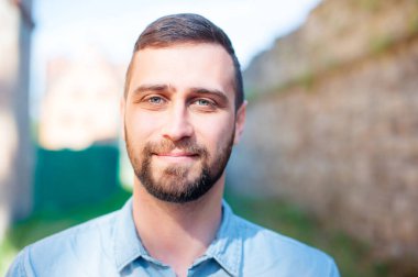 Çekici yakışıklı. Dışarıdaki kameraya bakan çekici, sakallı genç adamın portresini kapat.