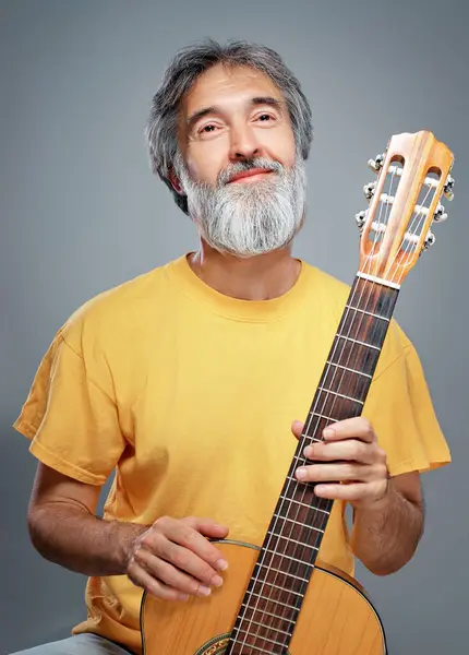 灰色の背景のギターを持つ高齢者男 — ストック写真